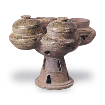 Sue ware: four clustered jars on tall foot.