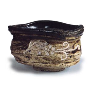 Black Oribe "shoe"-shaped tea bowl with scrolling grass design