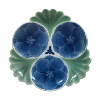 Dish with design of hibiscuses in circles. celadon glaze. andblue and white