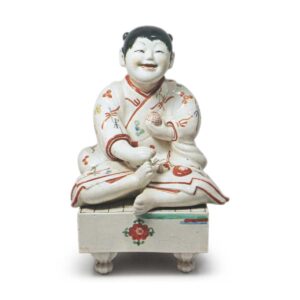 Figure of a boy seated on go-game board, enamelled ware