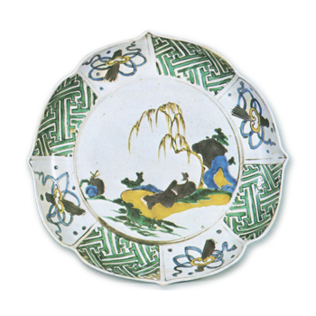 Foliated bowl on foot with design of figure lying under willow tree, enamelled ware
